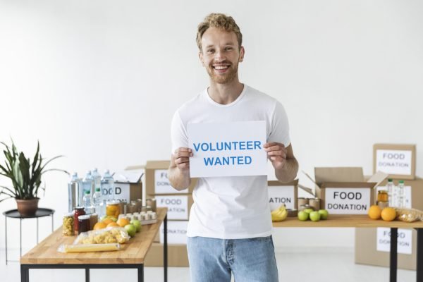 smiley-male-volunteer-holding-blank-paper